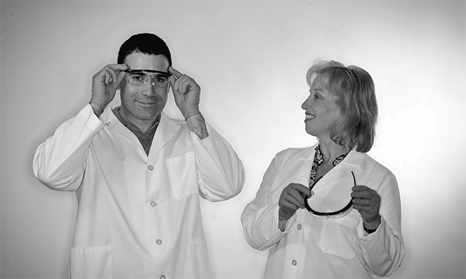 Two people in lab coats with safety glasses