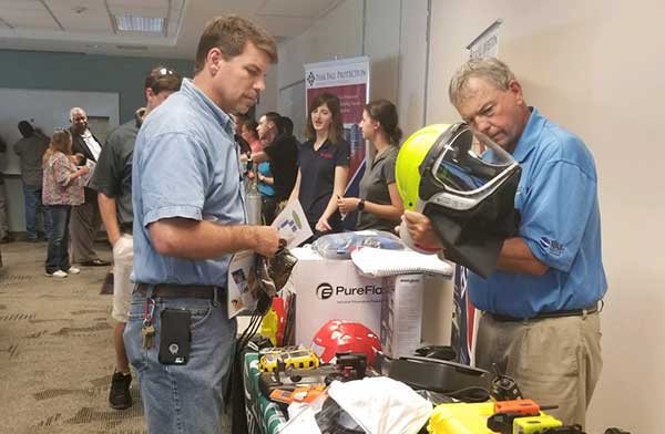 Participant and attendee viewing the features of a safety helmet