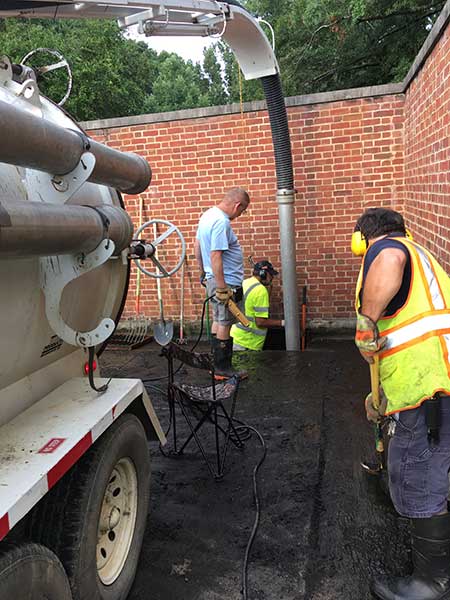Staff use a vacuum truck to pull sediment from an inlet.